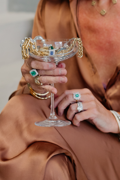 hands holding cup overflowing with jewellery