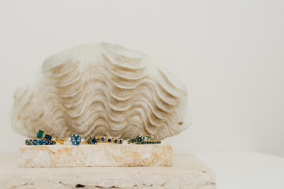 Dress rings with various gems on a stone block with a shell