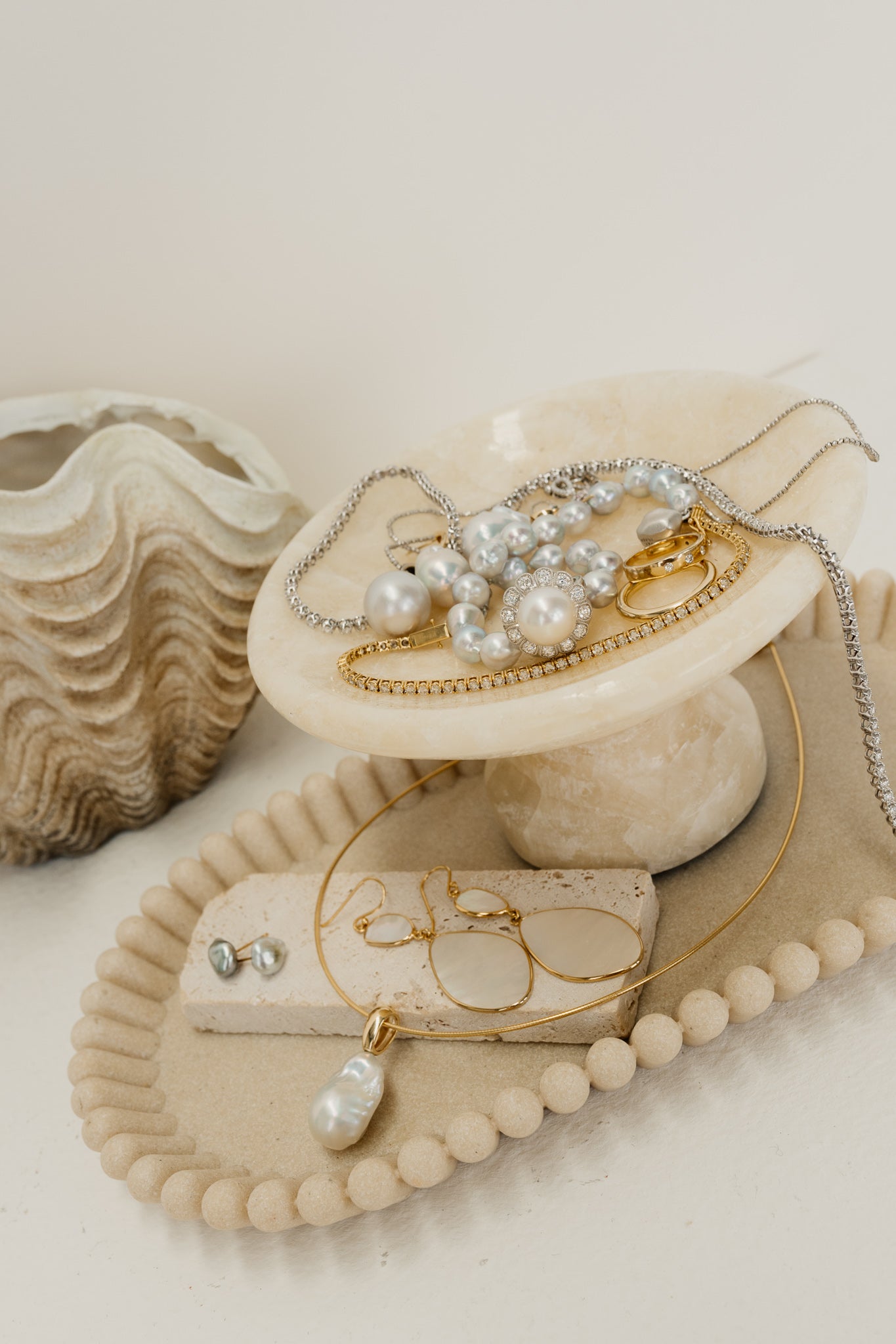 plate and stand covered in pearls, gold and diamond jewellery