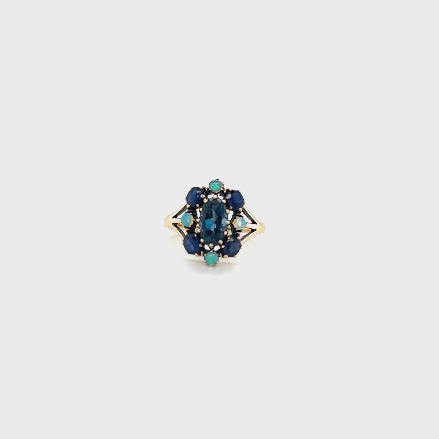 9 carat yellow gold ring with london blue topaz, sapphire and opals.