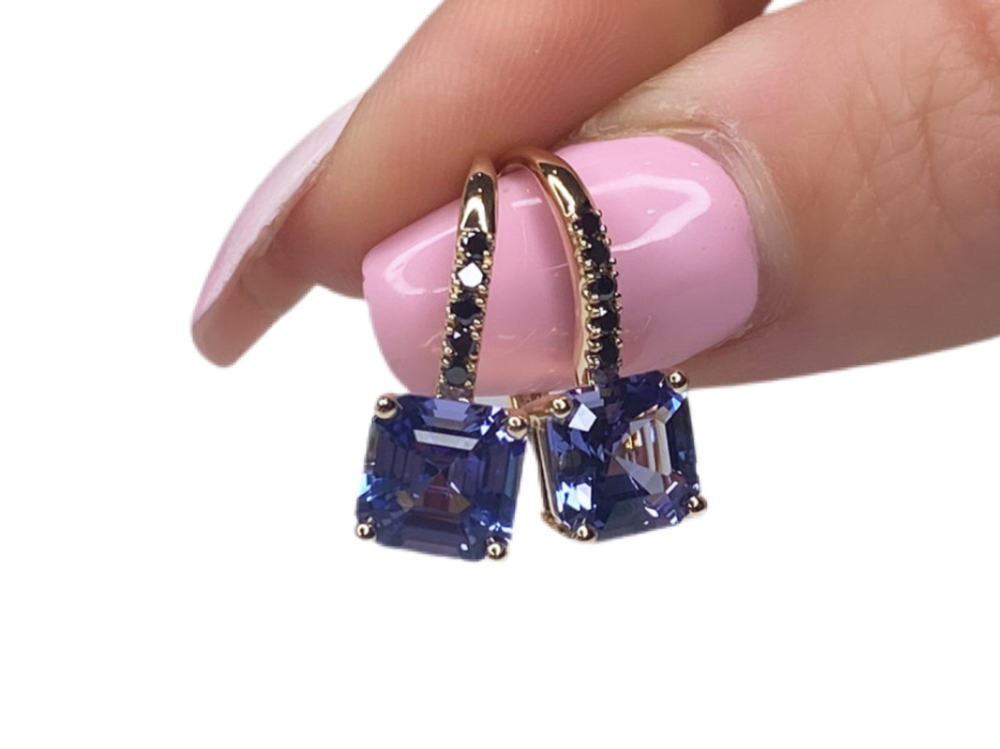 9ct tanzanite and black diamond earrings displayed on finger